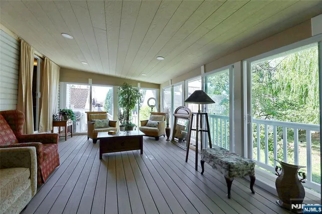 a spacious bathroom with a granite countertop sink a toilet a large mirror and a shower