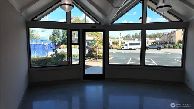 an empty room with wooden floor and a floor to ceiling window