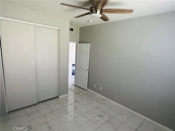 an empty room with a ceiling fan and a window