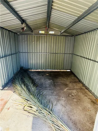 an empty room with a chandelier fan and windows