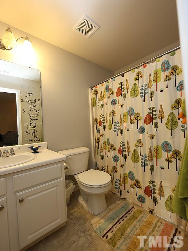 8208 Clasara Circle Raleigh, NC 27613 - Photo 13 of 19 a bathroom with a toilet and a shower curtain