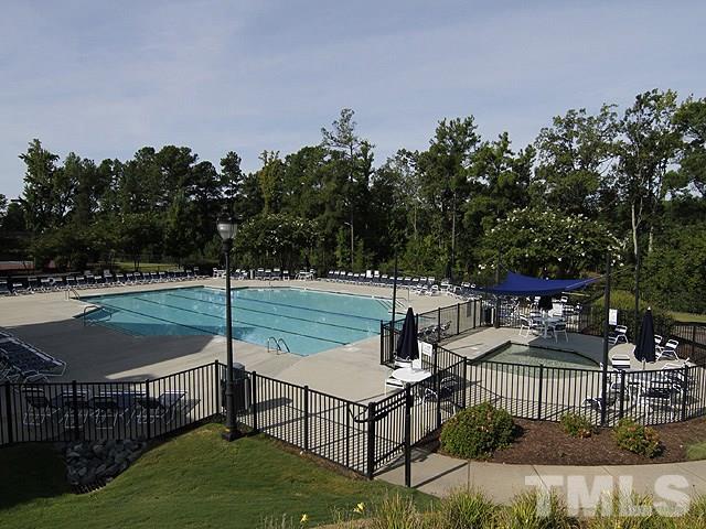 8208 Clasara Circle Raleigh, NC 27613 - Photo 18 of 19 a view of a patio with table and chairs potted plants with wooden fence