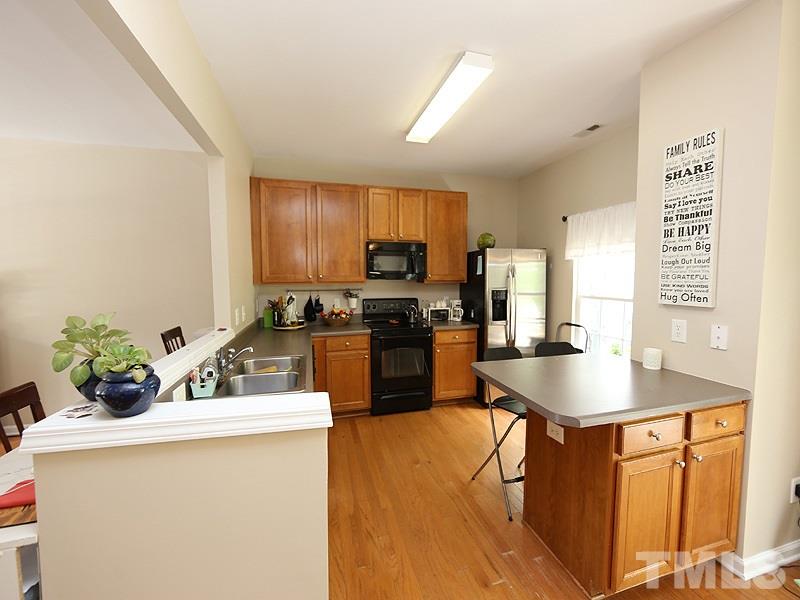 8208 Clasara Circle Raleigh, NC 27613 - Photo 5 of 19 a kitchen with granite countertop a sink counter top space and stainless steel appliances
