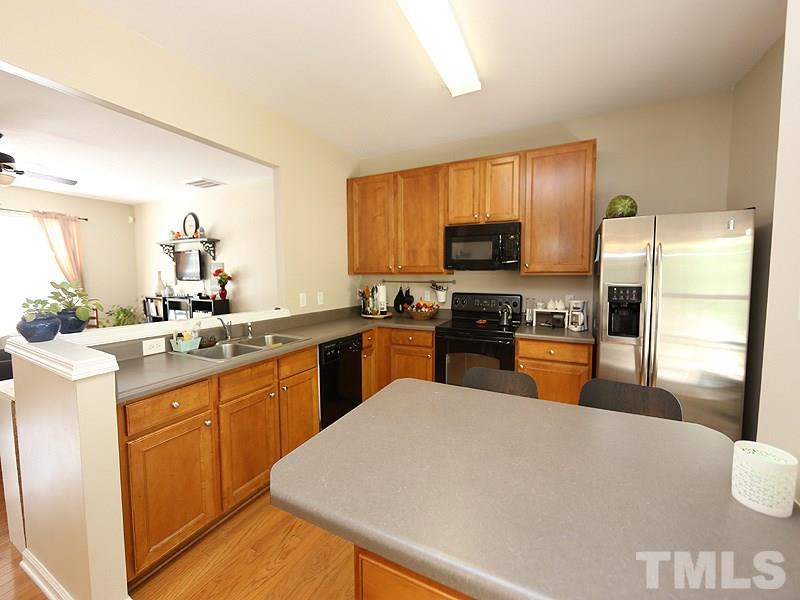 8208 Clasara Circle Raleigh, NC 27613 - Photo 6 of 19 a kitchen with granite countertop a refrigerator stove top oven and sink
