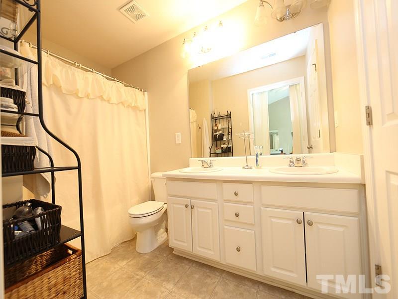 8208 Clasara Circle Raleigh, NC 27613 - Photo 10 of 19 a bathroom with a double vanity sink toilet and a mirror