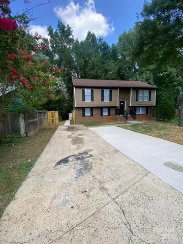 a front view of a house with a yard and trees