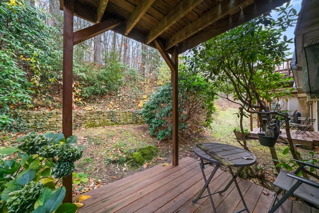 a view of a chairs and table in the patio next to a yard