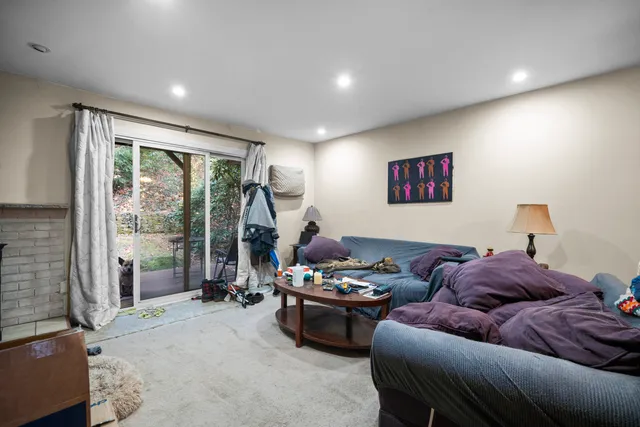 a living room with furniture a floor to ceiling window and a flat screen tv