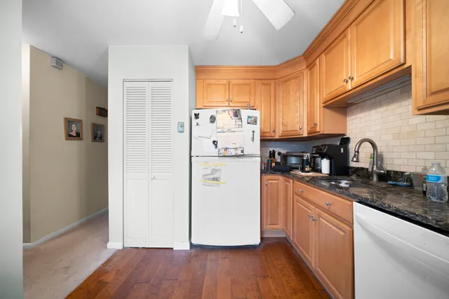 a kitchen with granite countertop wooden floors and white stainless steel appliances
