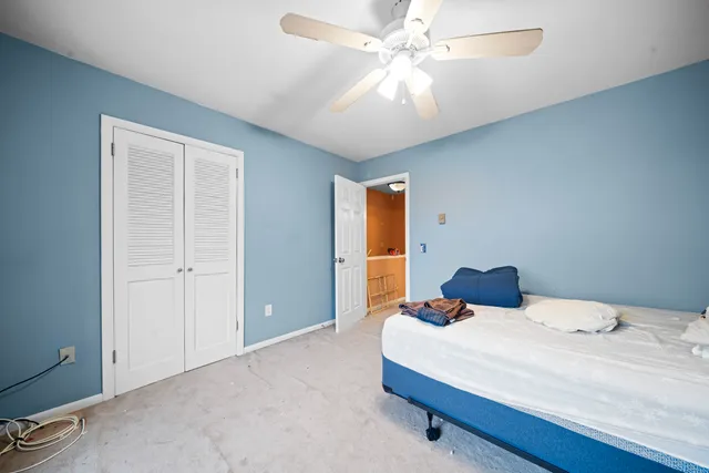 a bedroom with a large bed and a ceiling fan