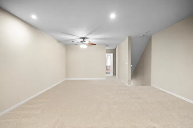a view of an empty room with a chandelier fan