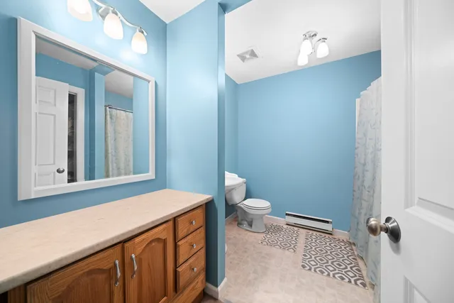 a bathroom with a sink a toilet and a mirror