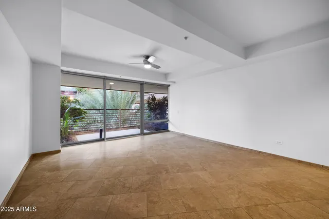 an empty room with wooden floor and glass door