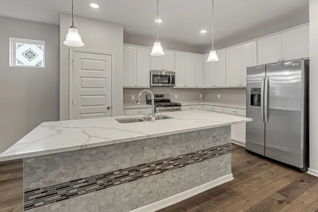a kitchen with kitchen island a sink stainless steel appliances and cabinets