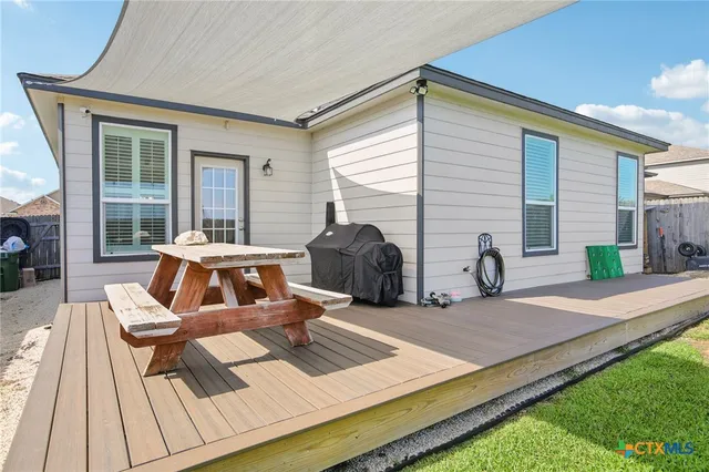 a view of a backyard with table and chairs with wooden fence