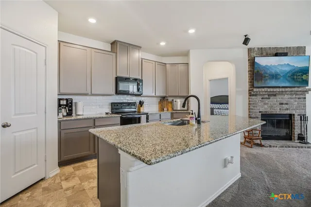 a kitchen with a stove a refrigerator and a dining table