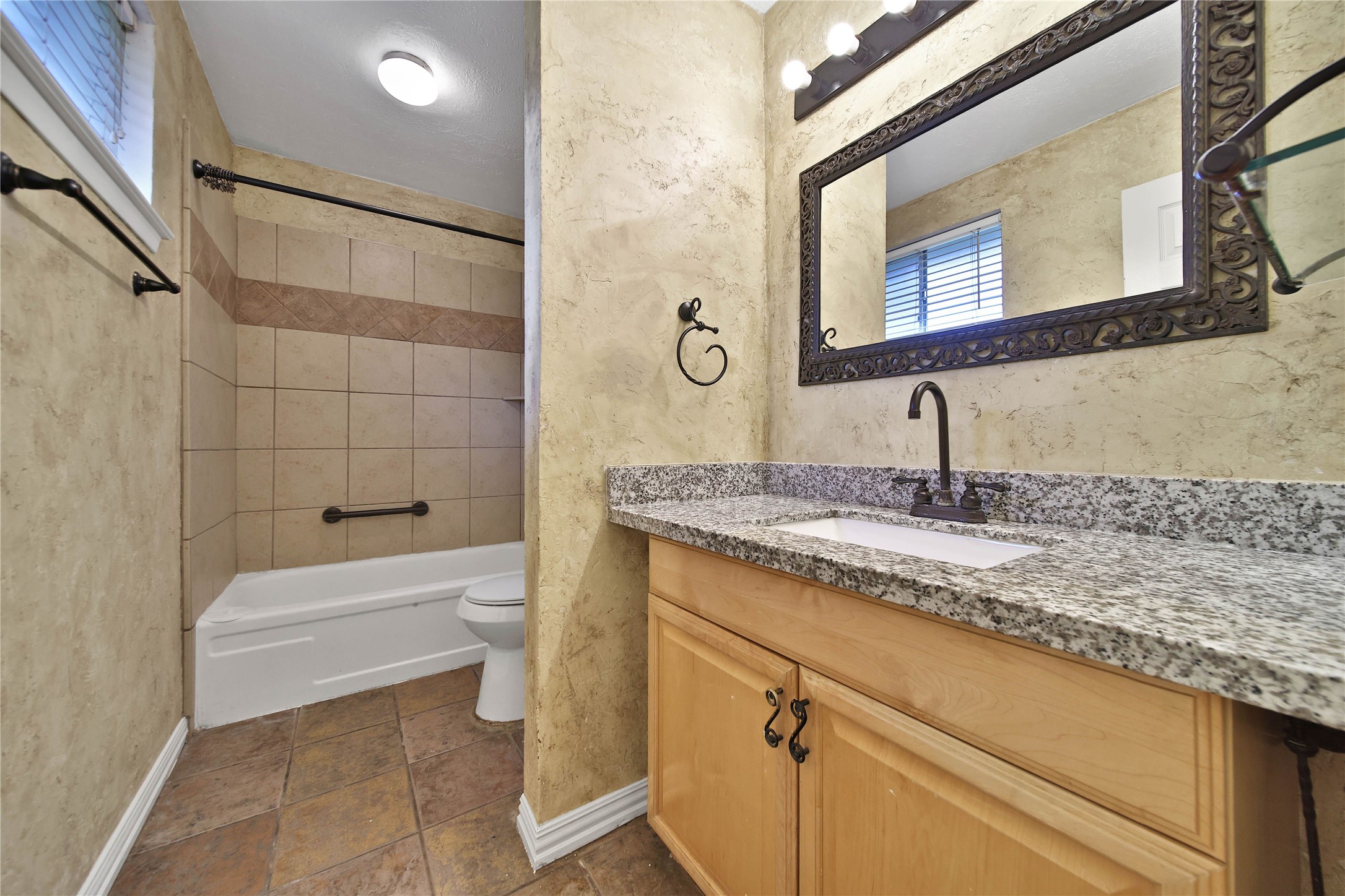 2006 Mermaid Lane Houston, TX 77062 - Photo 17 of 35 a bathroom with a granite countertop sink a toilet and bathtub