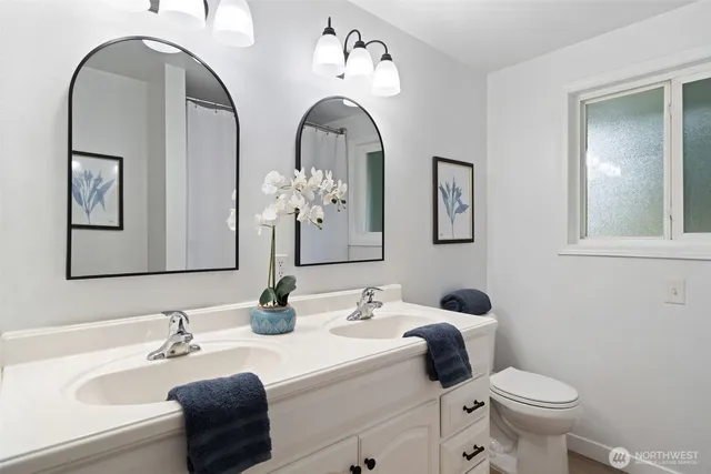 a bathroom with a toilet a sink and mirror