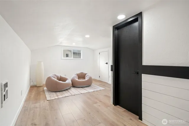 a view of a room with wooden floor and seating space
