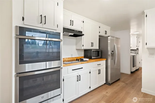 a kitchen with stainless steel appliances a stove a refrigerator and cabinets