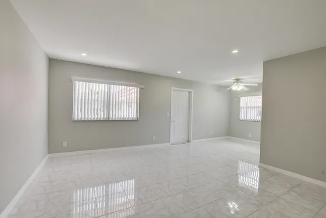 an empty room with a chandelier fan and closet area