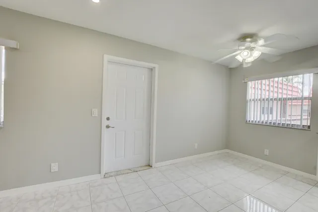 an empty room with a window and a fan