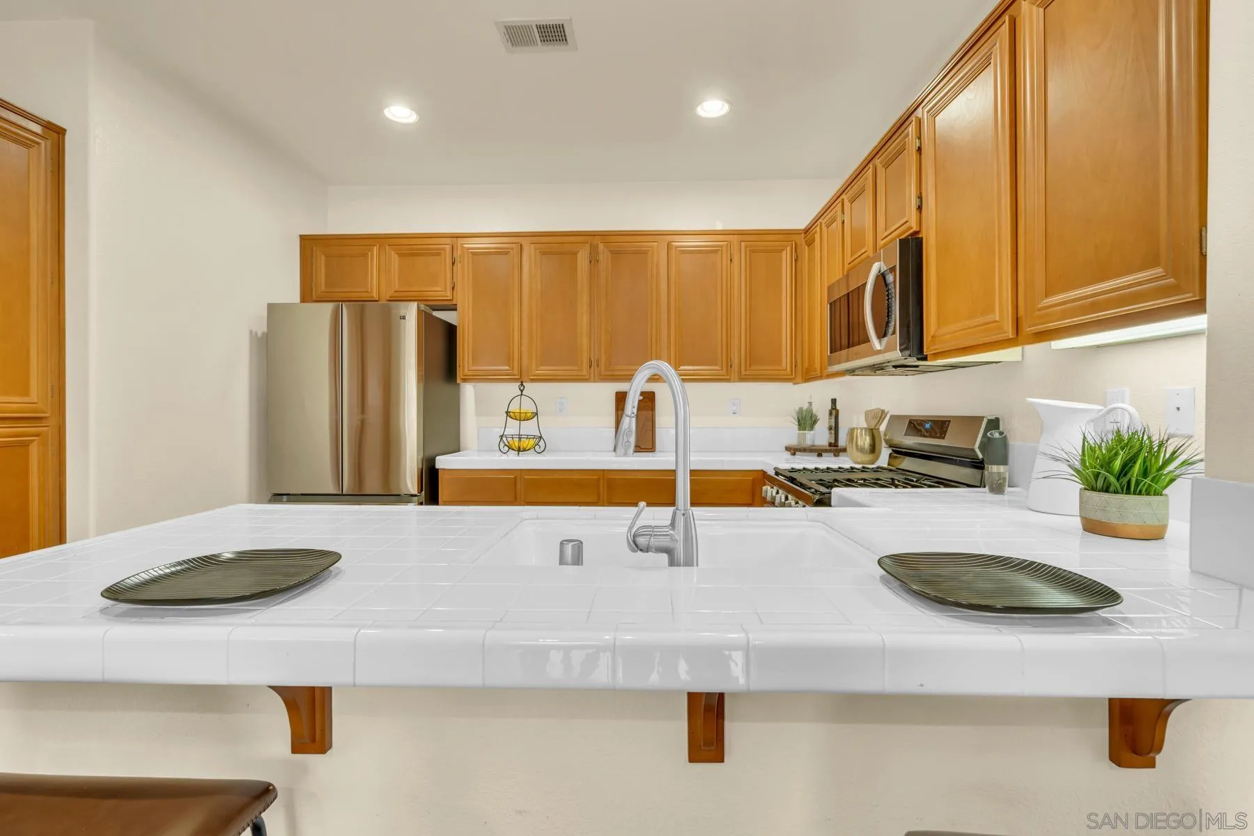 649 Sumner Way, Unit 6 Oceanside, CA 92058 - Photo 8 of 30 a kitchen with stainless steel appliances granite countertop a sink a refrigerator and a counter space