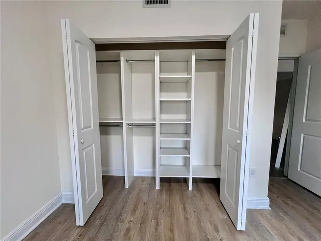 a view of walk in closet with empty racks