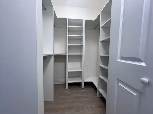 a view of walk in closet with empty racks