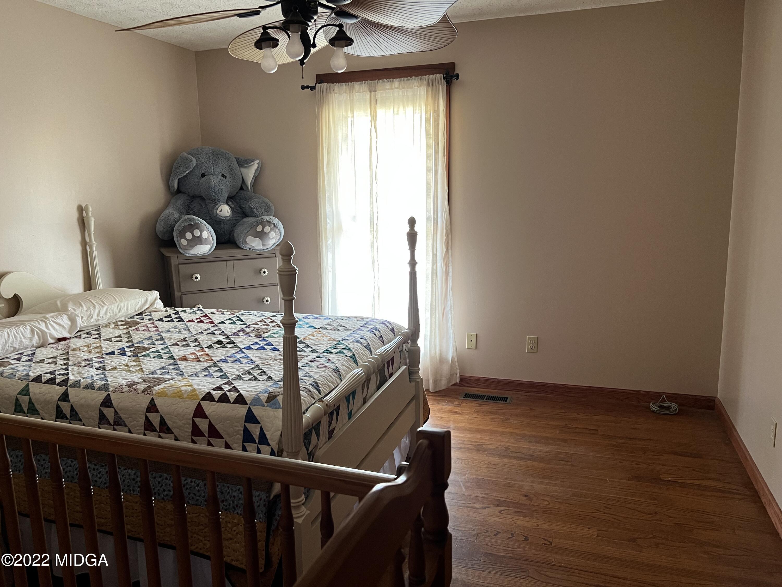 436 Barrow Road Reynolds, GA 31076 - Photo 32 of 91 a bedroom with a bed and wooden floor