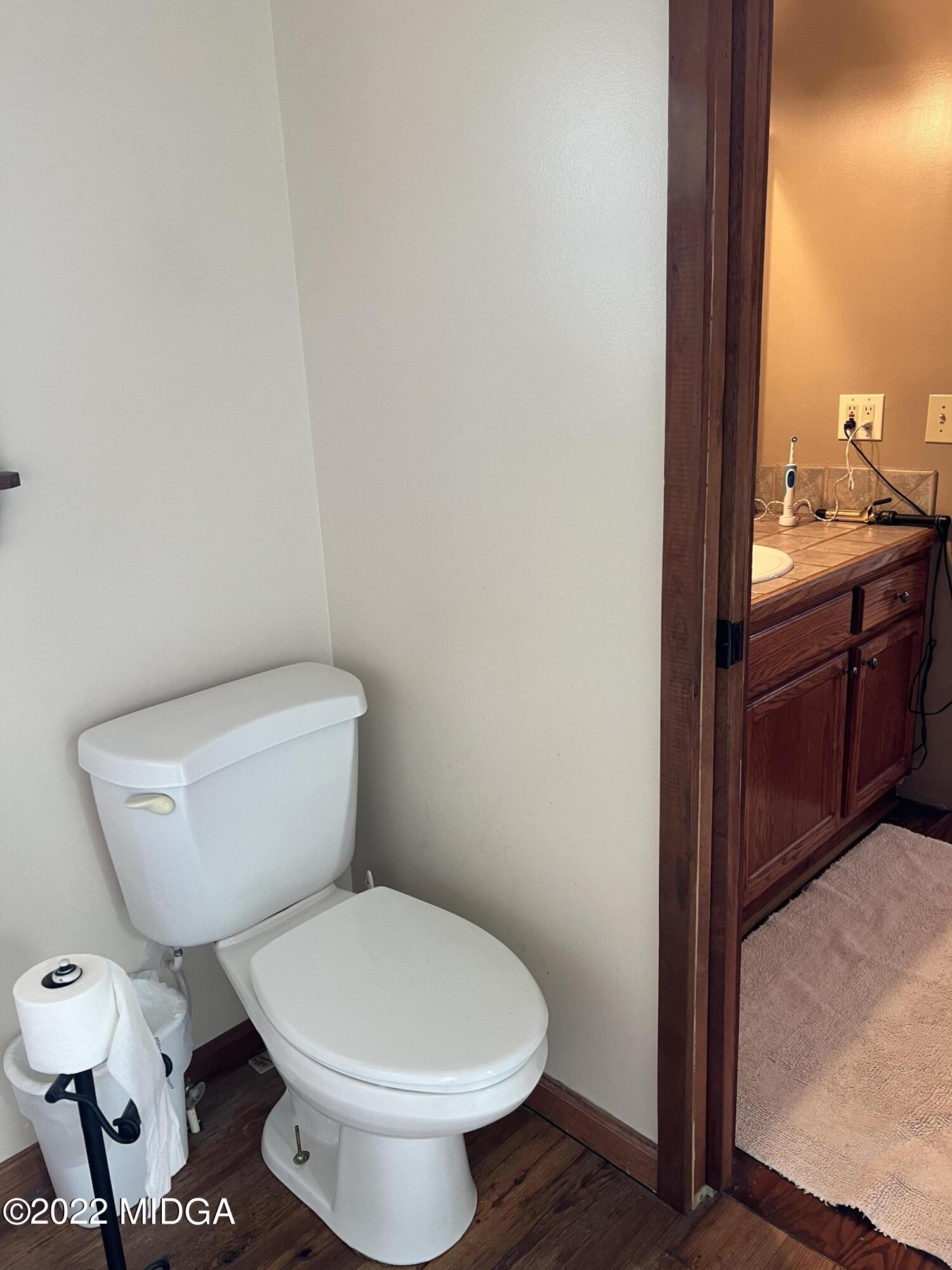 436 Barrow Road Reynolds, GA 31076 - Photo 41 of 91 a white toilet sitting next to a bathroom sink and vanity