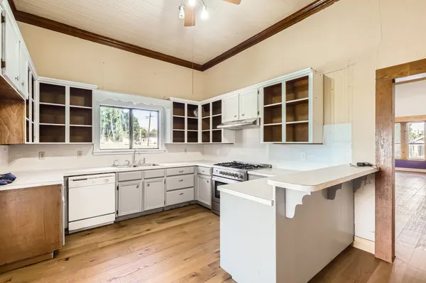 a kitchen with a stove sink and cabinets