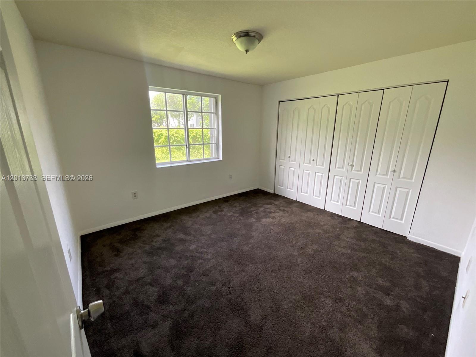209 Northeast 141st Street, Unit 4 Miami, FL 33161 - Photo 11 of 13 a view of an empty room with a window