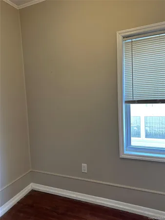 a view of a small space with wooden floor and a window