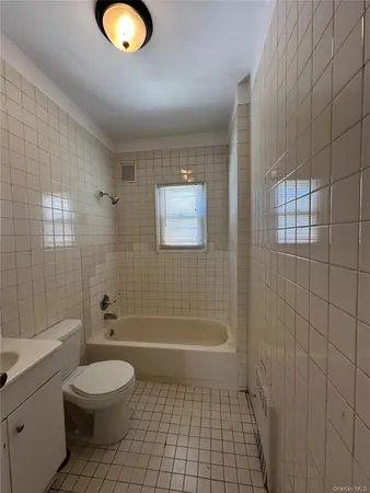a bathroom with a granite countertop toilet a sink a mirror and shower