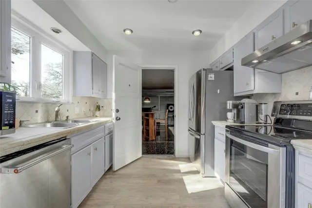 a kitchen with a sink cabinets and stainless steel appliances