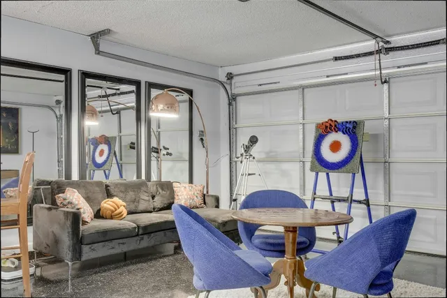 a living room with furniture a rug and a wall painting