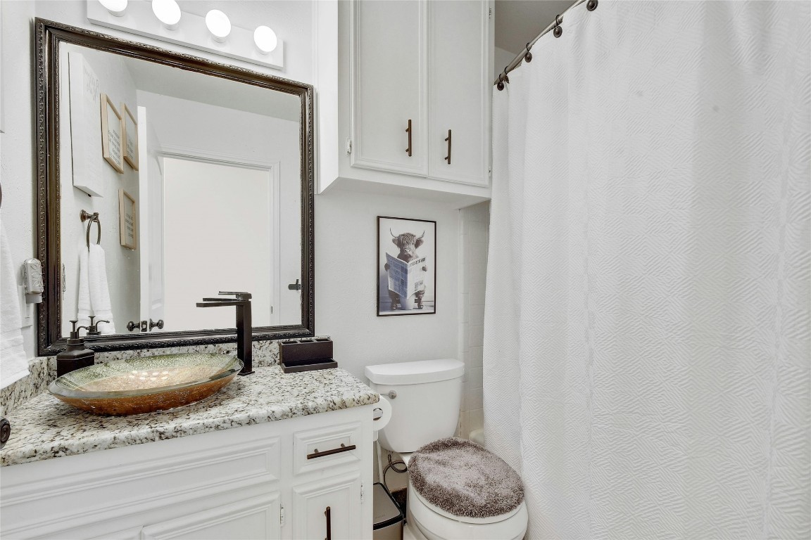 1503 Terrapin Court, Unit B Austin, TX 78746 - Photo 22 of 28 a bathroom with a granite countertop sink and a mirror