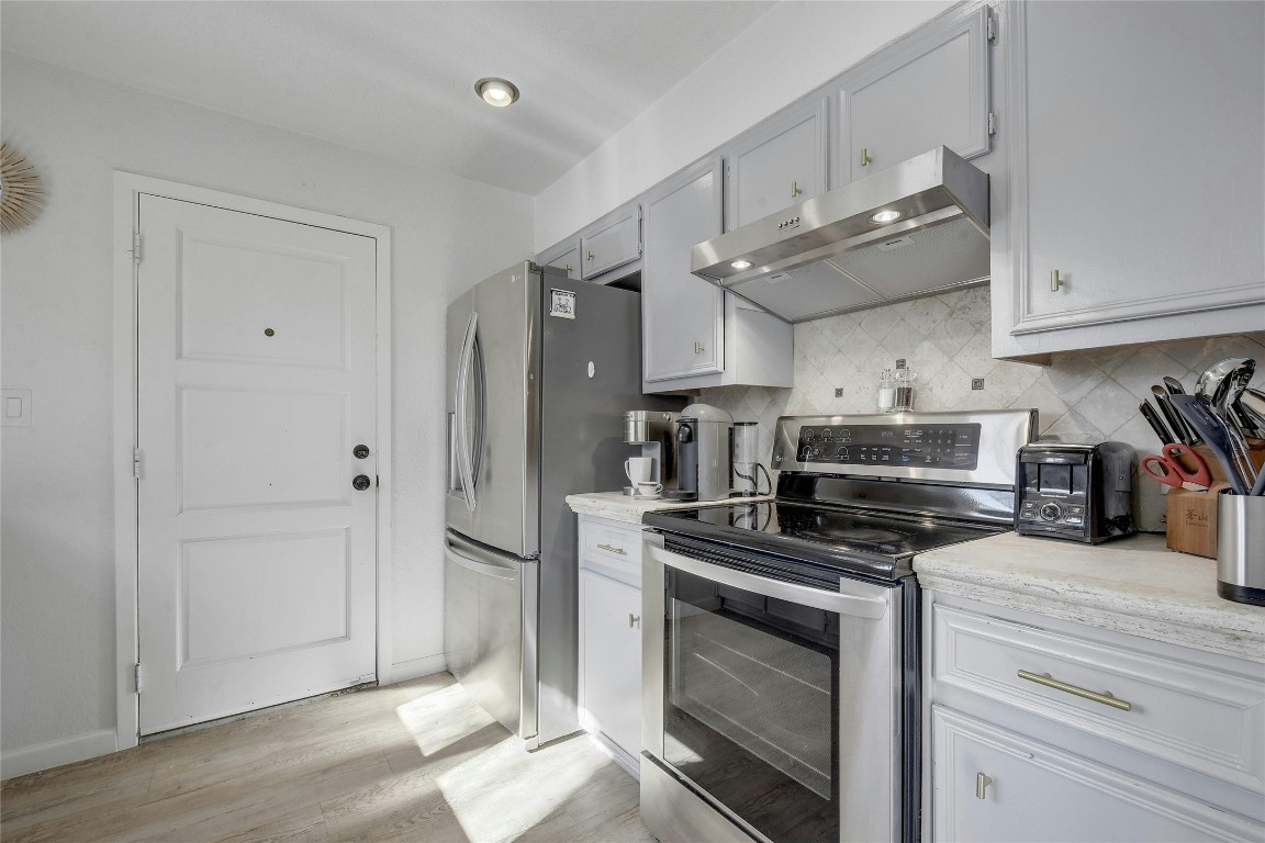 1503 Terrapin Court, Unit B Austin, TX 78746 - Photo 8 of 28 a kitchen with stainless steel appliances a stove a sink and a refrigerator