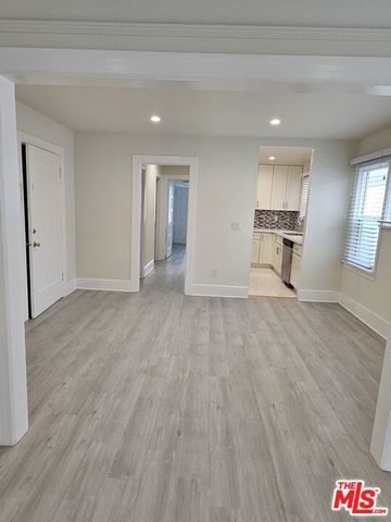 a view of empty room with kitchen and window