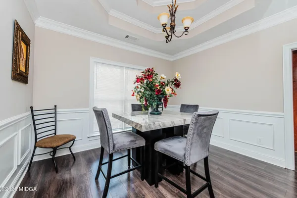 a dining room with furniture potted plants and wooden floor