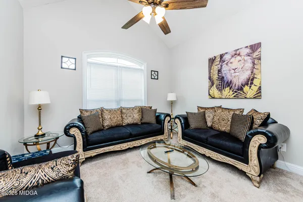 a living room with furniture a rug and a table