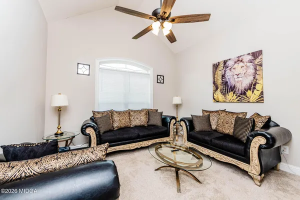 a living room with furniture a rug and a window
