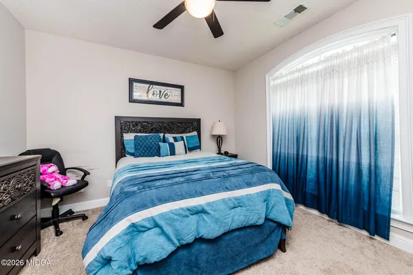 a bedroom with a bed and a potted plant