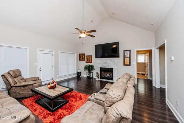 a living room with furniture a fireplace and a flat screen tv