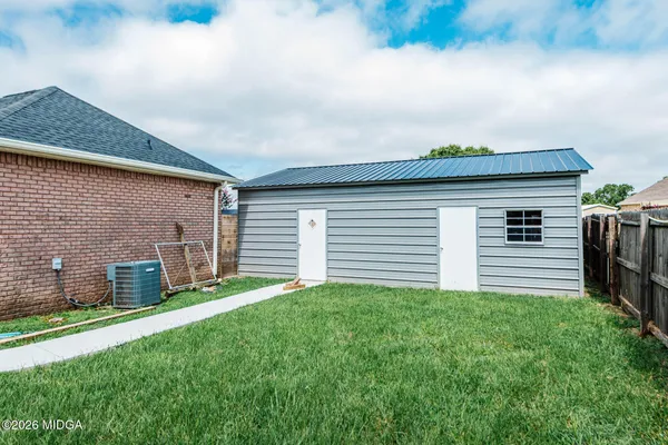 a backyard of a house with table and chairs