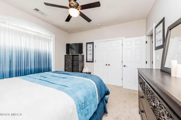 a spacious bedroom with a bed and a dresser