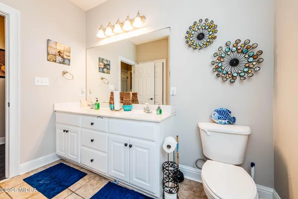 a bathroom with a toilet a sink and mirror