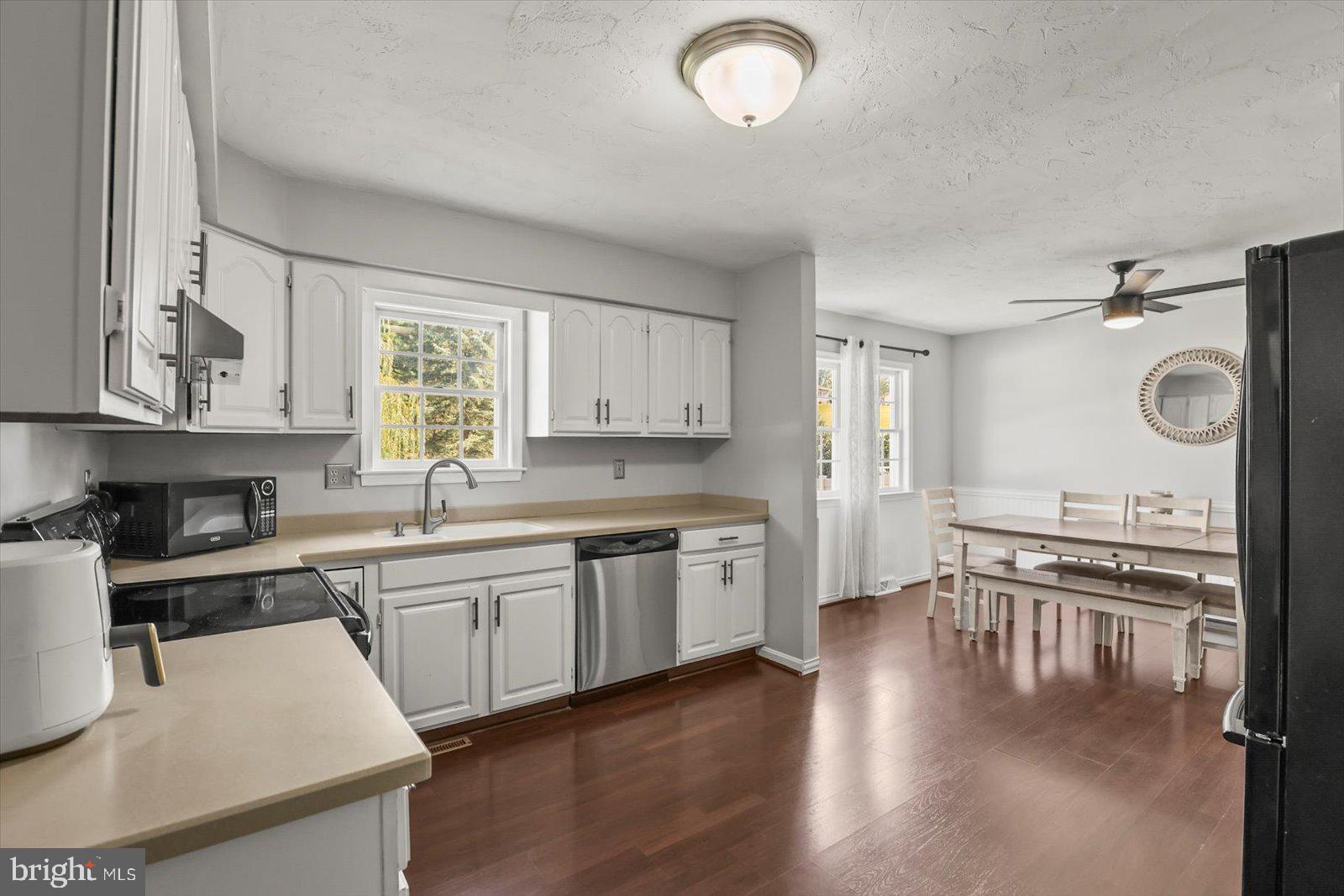 113 Timber Lane Hanover, PA 17331 - Photo 9 of 43 a kitchen with stainless steel appliances granite countertop a stove top oven a sink a dining table and chairs with wooden floor