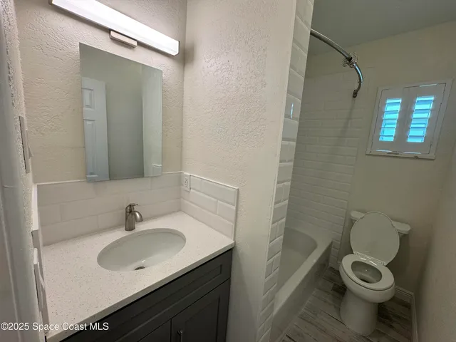 a bathroom with a sink toilet a mirror and shower